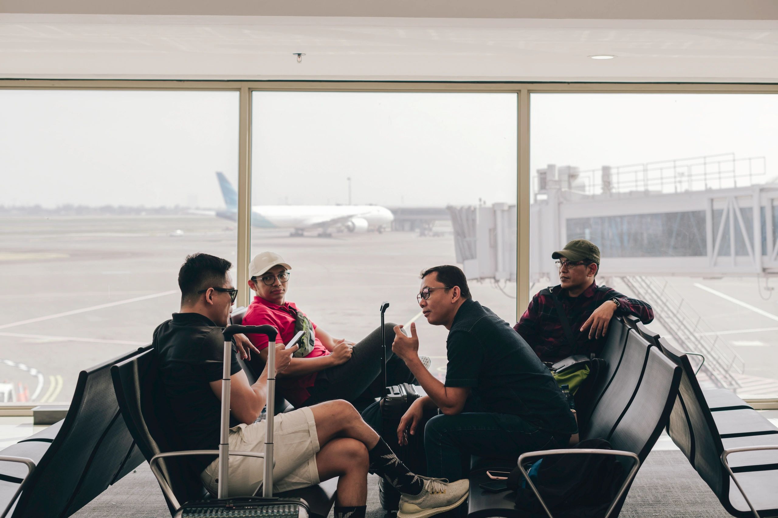 Medium shot travelers waiting for flight in departure area of airport